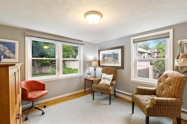 38 Pasho St, Andover, MA 01810 - living area with baseboard heating, wood finished floors, healthy amount of natural light, and a baseboard radiator