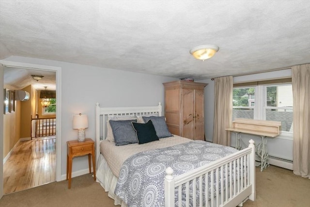 38 Pasho St, Andover, MA 01810 - bedroom with an AC wall unit, a textured ceiling, light carpet, and baseboard heating