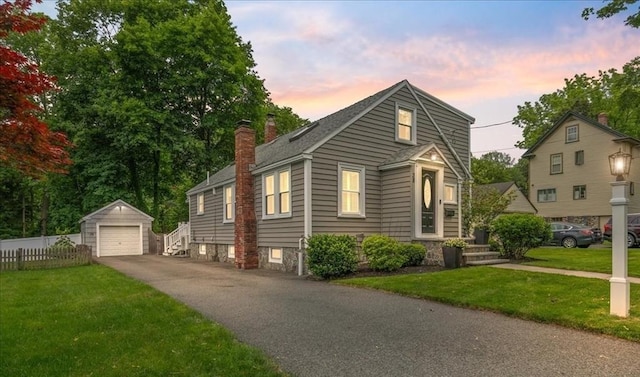38 Pasho St, Andover, MA 01810 - view of front facade featuring an outdoor structure, a chimney, a detached garage, asphalt driveway, and a shingled roof
