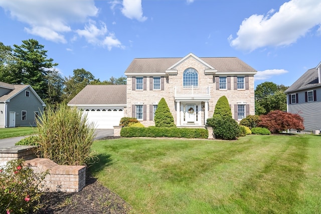 colonial-style house featuring a garage and a front yard