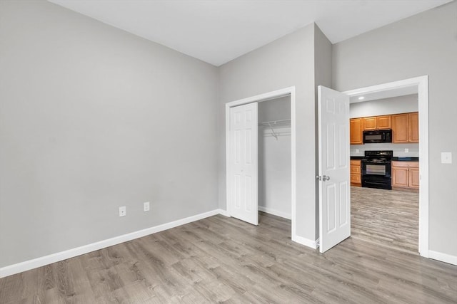 unfurnished bedroom featuring light wood finished floors, a closet, and baseboards