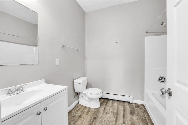 bathroom with toilet, wood finished floors, bathtub / shower combination, vanity, and a baseboard heating unit