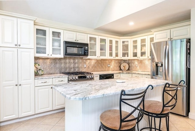 38 Gold Leaf, Mashpee, MA 02649 - kitchen featuring appliances with stainless steel finishes, light tile patterned floors, a breakfast bar, backsplash, and vaulted ceiling