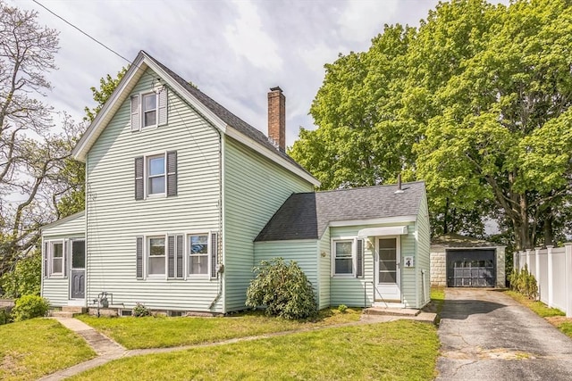 view of front facade featuring driveway, an outdoor structure, a chimney, a detached garage, and entry steps