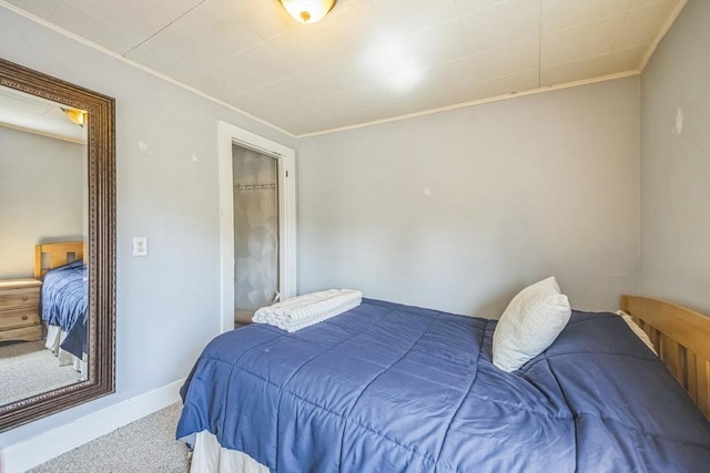 carpeted bedroom with crown molding and baseboards