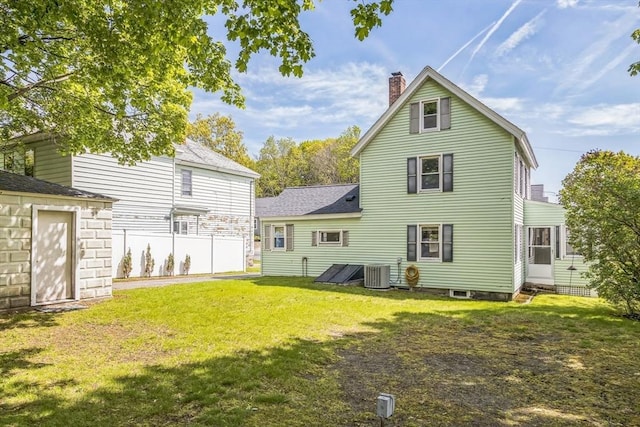 rear view of property with central AC, a chimney, and a shingled roof