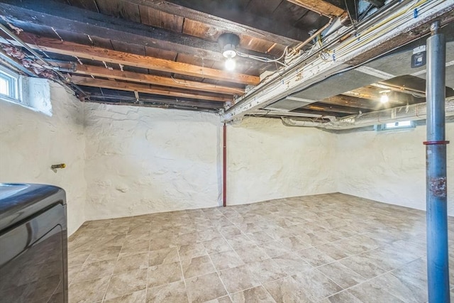 below grade area featuring washer / dryer and a textured wall