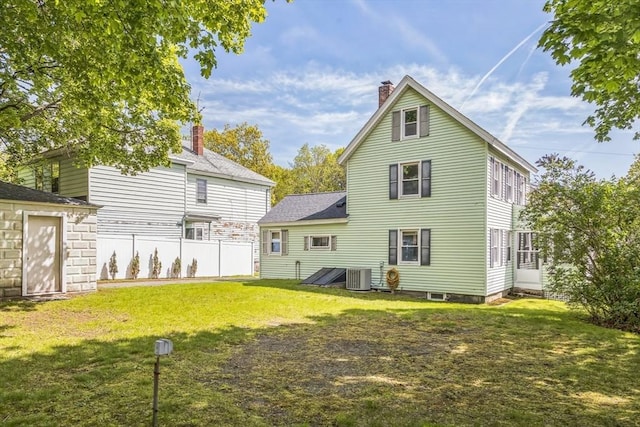 rear view of property featuring cooling unit and a chimney