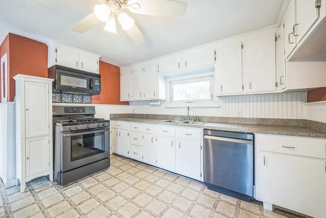 kitchen with stainless steel appliances, light flooring, a sink, a ceiling fan, and white cabinetry