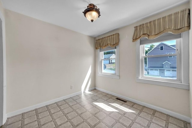 unfurnished room with light floors and baseboards