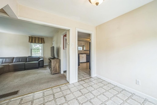 living area featuring light flooring and baseboards