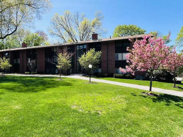 view of front of house featuring a chimney and a front yard