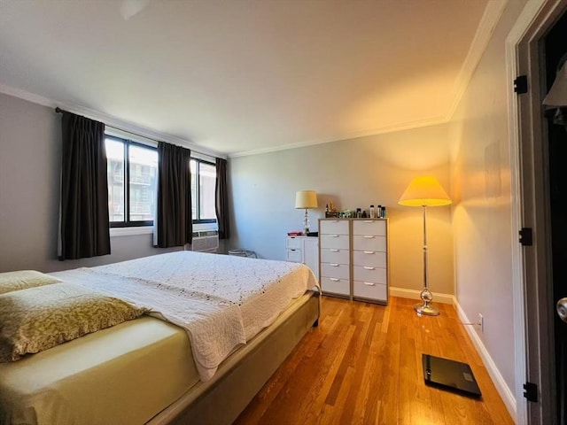 bedroom featuring crown molding, baseboards, and wood finished floors