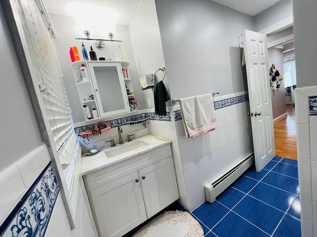 bathroom featuring vanity, tile patterned flooring, a baseboard heating unit, and tile walls