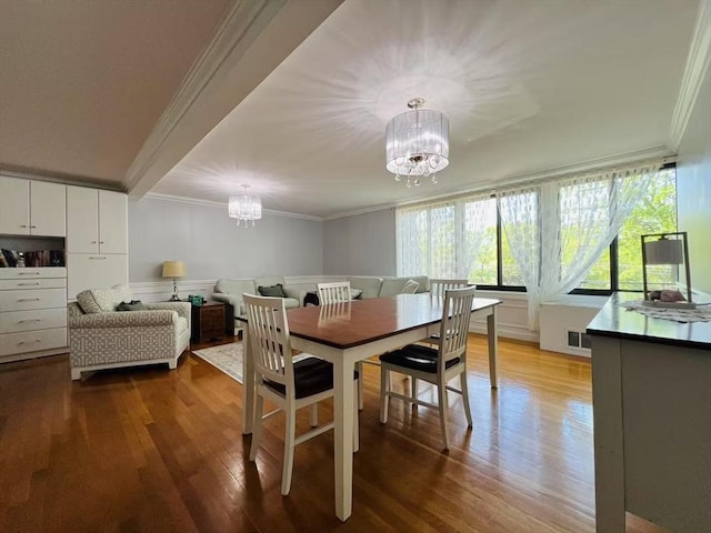 dining room with crown molding, visible vents, wood finished floors, and a notable chandelier