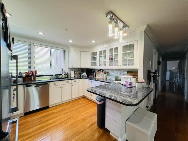 kitchen with stainless steel dishwasher, crown molding, a peninsula, white cabinets, and light wood finished floors