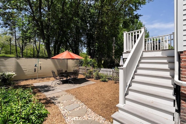fenced backyard with stairs and a patio area