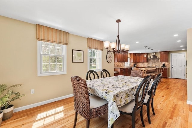dining area featuring baseboards, recessed lighting, light wood-style flooring, and a chandelier