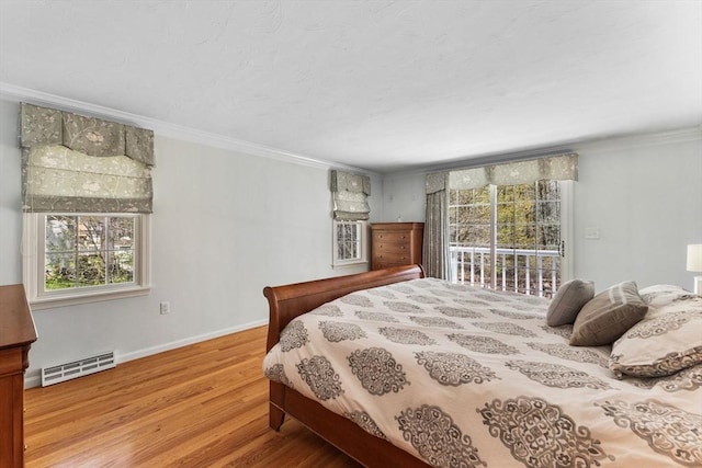 bedroom with visible vents, wood finished floors, baseboards, ornamental molding, and access to outside