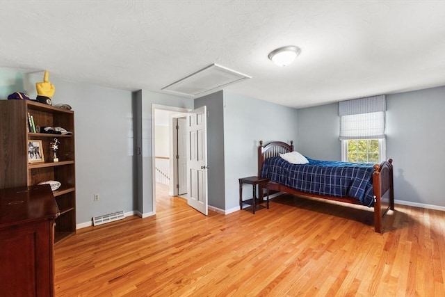 bedroom featuring baseboards, visible vents, light wood-style flooring, and attic access