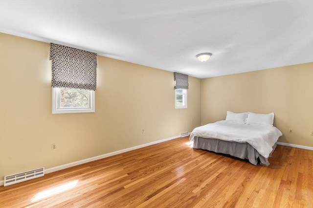 bedroom featuring baseboards, visible vents, and light wood-type flooring
