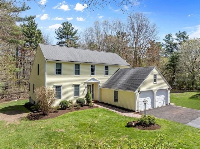 view of front of home with roof with shingles, a garage, aphalt driveway, and a front yard