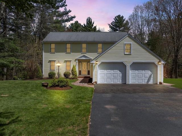 view of front facade with an attached garage, driveway, and a front lawn
