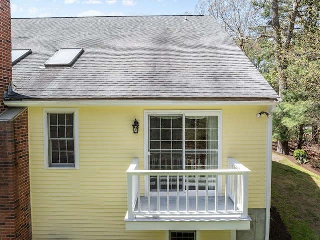 rear view of property with a shingled roof