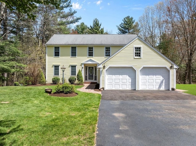 view of front of property featuring an attached garage, a front lawn, and driveway