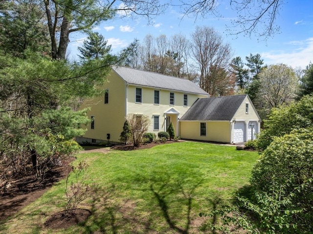 view of front of home featuring a garage, an outdoor structure, and a front lawn