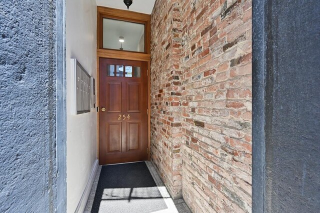 view of exterior entry featuring brick siding