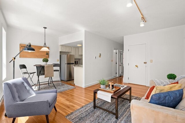 living area with baseboards and light wood finished floors