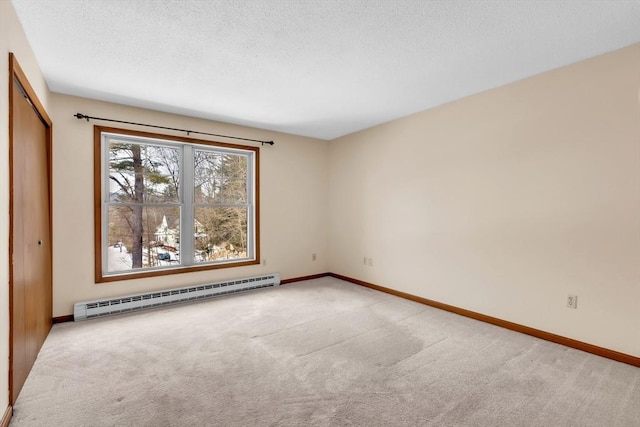 unfurnished room featuring light carpet, a textured ceiling, and baseboard heating