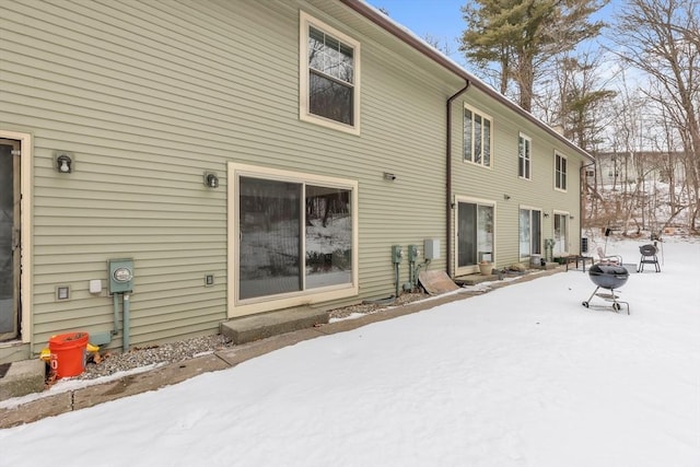 view of snow covered back of property