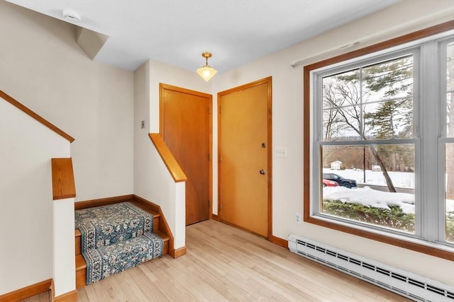 foyer featuring baseboard heating and light hardwood / wood-style floors