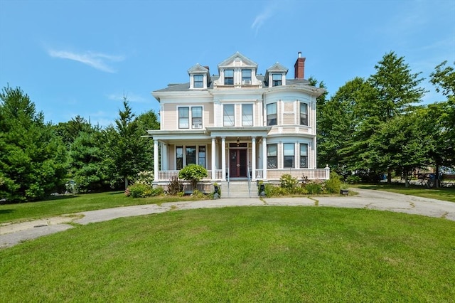 victorian house with covered porch and a front lawn