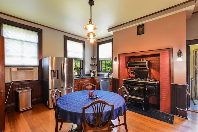 dining space with cooling unit, sink, light hardwood / wood-style flooring, and ornamental molding