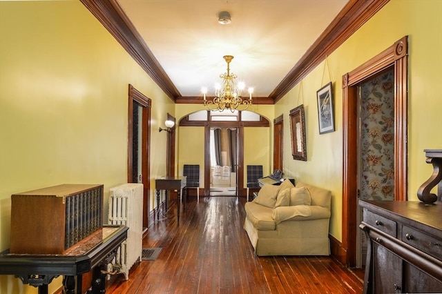 interior space with crown molding, dark hardwood / wood-style floors, radiator, and an inviting chandelier