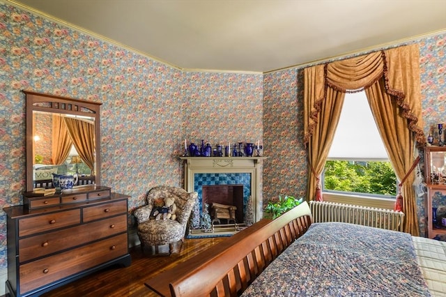 bedroom with hardwood / wood-style flooring, a fireplace, and radiator