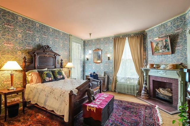 bedroom featuring radiator, hardwood / wood-style floors, and a fireplace