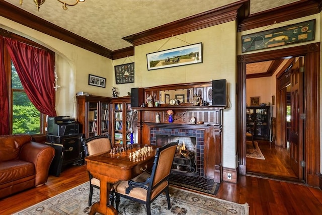 sitting room featuring crown molding, wood-type flooring, and a tile fireplace