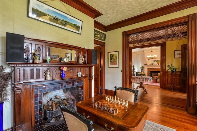 dining room with crown molding, a chandelier, hardwood / wood-style floors, and a textured ceiling