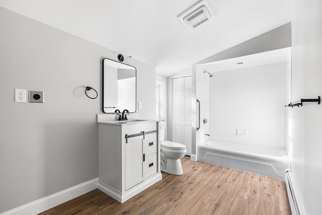 bathroom with a baseboard heating unit, vanity, wood finished floors, and visible vents