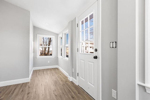 entryway with lofted ceiling, light wood-type flooring, baseboards, and a wealth of natural light