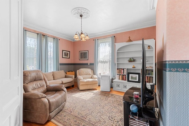 41 Edwards St, Southbridge, MA 01550 - living area featuring a chandelier, healthy amount of natural light, wood finished floors, wainscoting, and crown molding