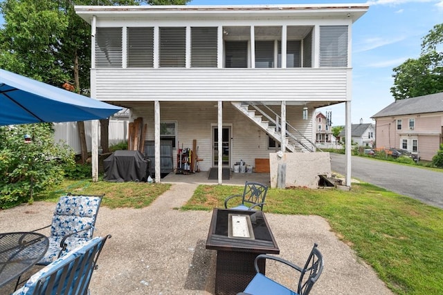 41 Edwards St, Southbridge, MA 01550 - back of property with a fire pit, a patio, a sunroom, and stairs