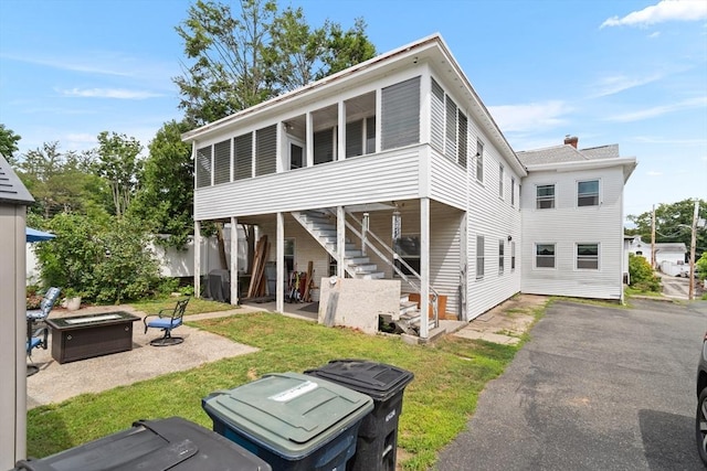 41 Edwards St, Southbridge, MA 01550 - rear view of property with a sunroom, stairs, a patio area, a fire pit, and asphalt driveway