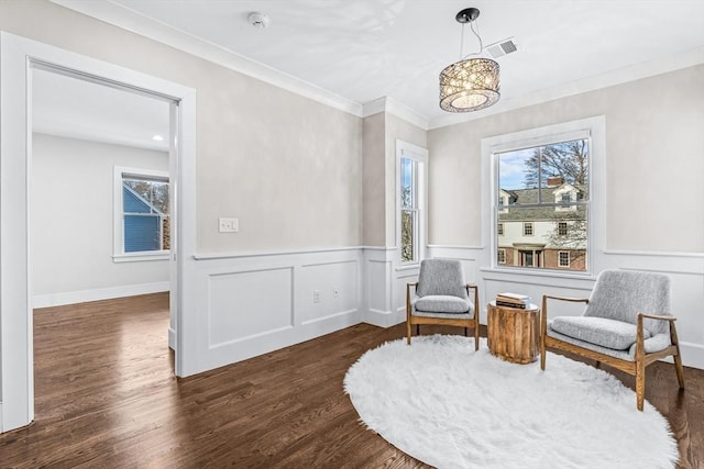 living area featuring dark wood-type flooring, ornamental molding, and a wealth of natural light