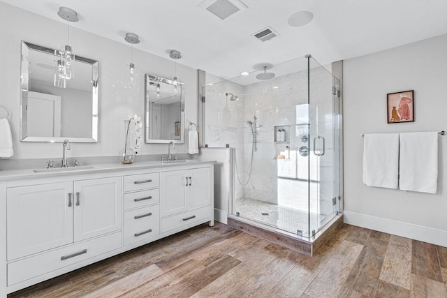 bathroom with wood-type flooring, vanity, and walk in shower