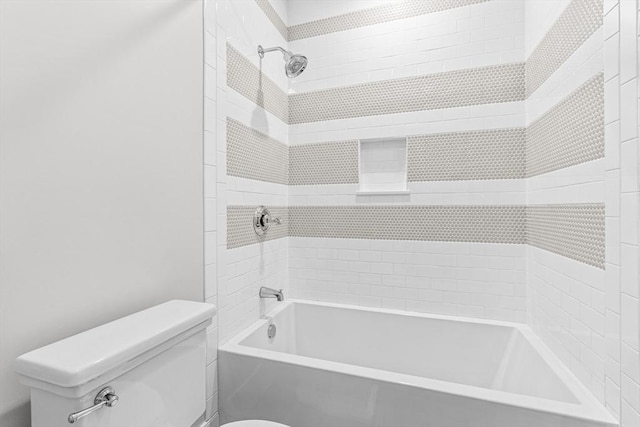 bathroom with toilet and tiled shower / bath combo